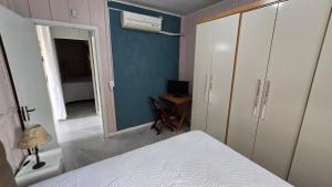a bedroom with a bed and a desk and a mirror at Casa da vó cida in Itapoa +1 photo