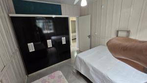 a bedroom with a black door and a bed in it at Casa da vó cida in Itapoa
