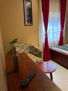 a living room with a couch and a table with a remote control at Binyuma Suites Motel in Kampala