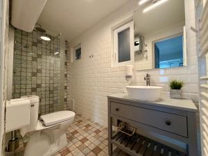 a white bathroom with a sink and a toilet at Avar Inn in Tiszalök