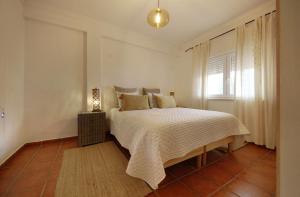 a bedroom with a bed and a window at Apartamento Azur in Vila Nova de Milfontes