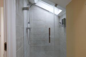 a bathroom with a shower with a glass door at Converted Coastal Coach House in Weston-super-Mare +24 photos