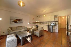 a living room with a couch and a table at Apartamento Azur in Vila Nova de Milfontes +6 photos