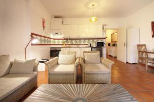 a living room with two couches and a kitchen at Apartamento Azur in Vila Nova de Milfontes