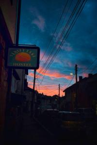 a sign for a restaurant with a sunset in the background at Sunset Lake hostel in Ohrid