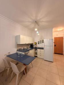 a kitchen with a blue table and a refrigerator at נוף ראשון לים in Ashkelon