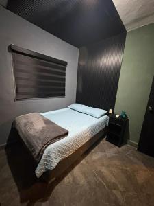a small bedroom with a bed and a window at Departamento Mateos 501 in Ciudad Acuña