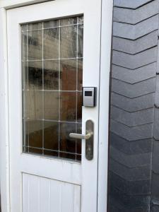 a white door with a handle on a house at Wandergesellenzimmer mit Bad und Küche in Ilmenau