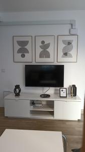 a living room with a television on a white table at Los Naranjos de Marbella in Marbella