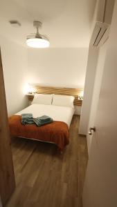 a bedroom with a bed with white sheets and wood floors at Los Naranjos de Marbella in Marbella