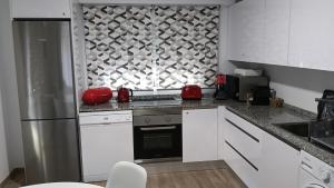 a kitchen with white cabinets and a stainless steel refrigerator at Los Naranjos de Marbella in Marbella