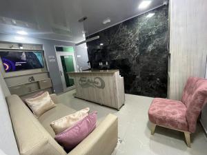 a living room with a couch and chairs and a tv at Hotel Aquamarina Maicao in Maicao