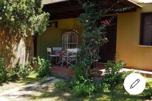 a porch of a house with a table and flowers at Villa Celeste in Torre delle Stelle