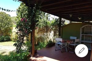 a covered patio with a table and a tree at Villa Celeste in Torre delle Stelle