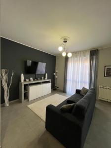 a living room with a black couch and a flat screen tv at Ladybug in Canale