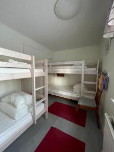 a room with three bunk beds with a red rug at Villa nära Järvsö in Järvsö
