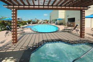 a swimming pool with chairs and a pergola at Houston Marriott Energy Corridor in Houston
