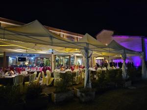 a group of tables and chairs under tents at night at Hotel Antica Tabaccaia Resort in Terranuova Bracciolini +141 photos
