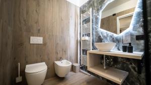 a bathroom with a toilet and a sink at ESTENSIA Room & Suite in Ferrara