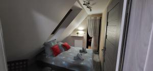 a small bedroom with a bed with red pillows at Domek na Polance in Istebna