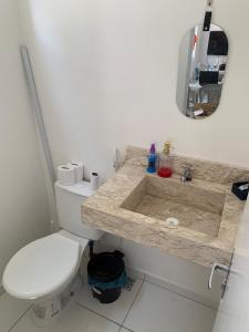 a bathroom with a white toilet and a sink at Casa condominio Reserva do Delta 07 in Parnaíba +4 photos