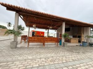 a pavilion with two benches and a table and a kitchen at Casa condominio Reserva do Delta 07 in Parnaíba