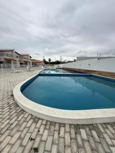 a large swimming pool with blue water in a yard at Casa condominio Reserva do Delta 07 in Parnaíba