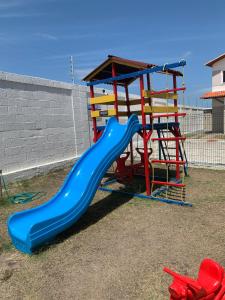 a playground with a blue slide in a yard at Casa condominio Reserva do Delta 07 in Parnaíba