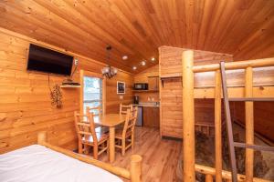 a log cabin bedroom with a desk and a bunk bed at Jellystone Park Tower Park Resort in Lodi
