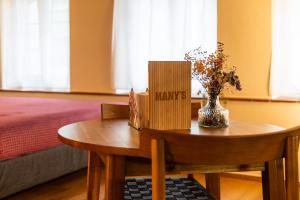 a table with books and a vase of flowers on it at MANY'S historical city central APARTMENTS in Zurich +4 photos