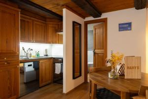 a kitchen with wooden cabinets and a wooden table at MANY'S historical city central APARTMENTS in Zurich
