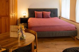 a bedroom with a bed and a wooden table with a table at MANY'S historical city central APARTMENTS in Zurich