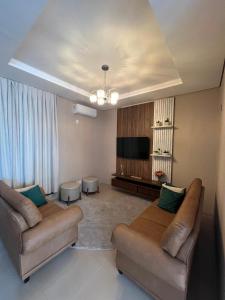 a living room with two couches and a flat screen tv at HOTEL PLAZA PONTES e LACERDA in Pontes e Lacerda