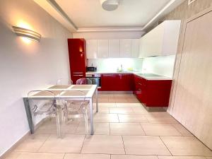 a kitchen with red cabinets and a table and chairs at Paris Garden Rooms in Debrecen