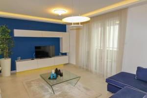 a living room with a couch and a tv at Paris Garden Rooms in Debrecen