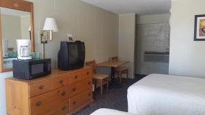 Pokój hotelowy z łóżkiem i telewizorem na komodzie w obiekcie Admiral Motor Inn w mieście Myrtle Beach