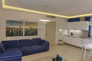 a living room with a blue couch and a kitchen at Paris Garden Rooms in Debrecen +6 photos