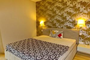 a bedroom with a large bed with two lamps at Paris Garden Rooms in Debrecen