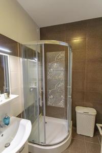 a bathroom with a shower and a toilet and a sink at Paris Garden Rooms in Debrecen