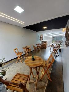 a dining room with wooden tables and chairs at Quarto Duplo Comercial - Queen's Hotel in Formosa