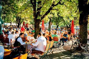 a group of people sitting at tables in a park at Sure Hotel by Best Western Muenchen Hauptbahnhof in Munich