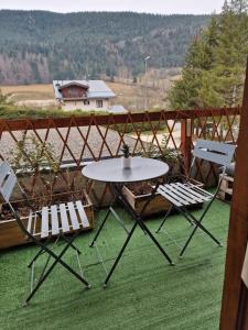 two chairs and a table and a table and two chairs at Studio rénové avec terrasse, parking , proche pistes,Villard de Lans in Villard-de-Lans