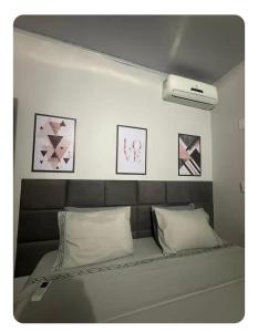 a bed in a room with pictures on the wall at Casa da Vila de São Jorge in Sao Jorge