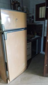 a kitchen with a refrigerator and a sink at Chalé da Janete in Capão da Canoa +1 photo