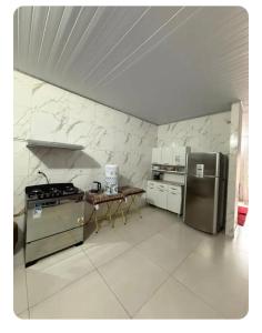 a kitchen with a stainless steel refrigerator and a table at Casa da Vila de São Jorge in Sao Jorge