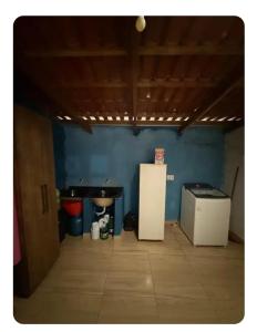 a room with a blue wall and a refrigerator at Casa da Vila de São Jorge in Sao Jorge +7 photos