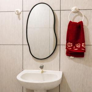 a bathroom sink with a mirror and a red towel at Ybirá - Casa Inteira no Centro de Alter do Chão in Alter do Chao