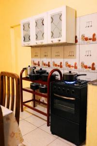 a kitchen with a stove and some pots and pans at Ybirá - Casa Inteira no Centro de Alter do Chão in Alter do Chao