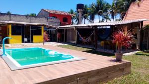 a backyard with a swimming pool and a house at Chalé a beira mar ilhéus in Ilhéus