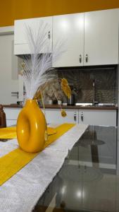 a yellow vase sitting on a table in a kitchen at Lumèra Holiday Home in Pizzo +4 photos
